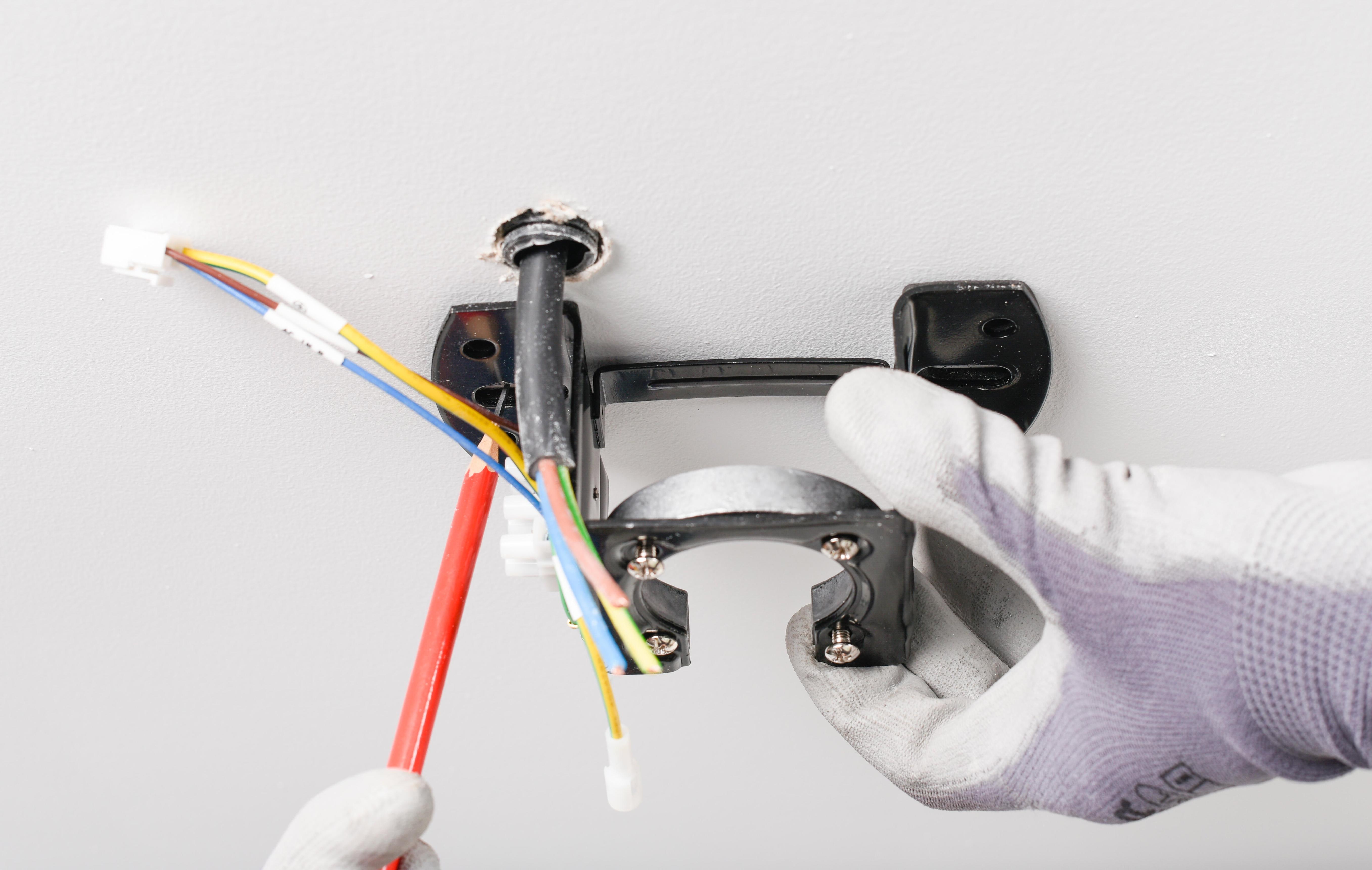 Lắp trục treo và cố định thân động cơ quạt trần vào giá đỡ trên trần nhà